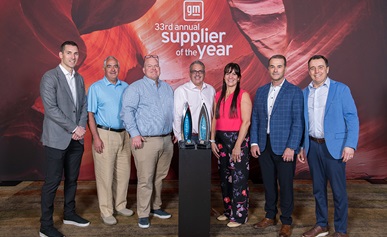 Group of people standing behind GM Supplier of the Year Award
