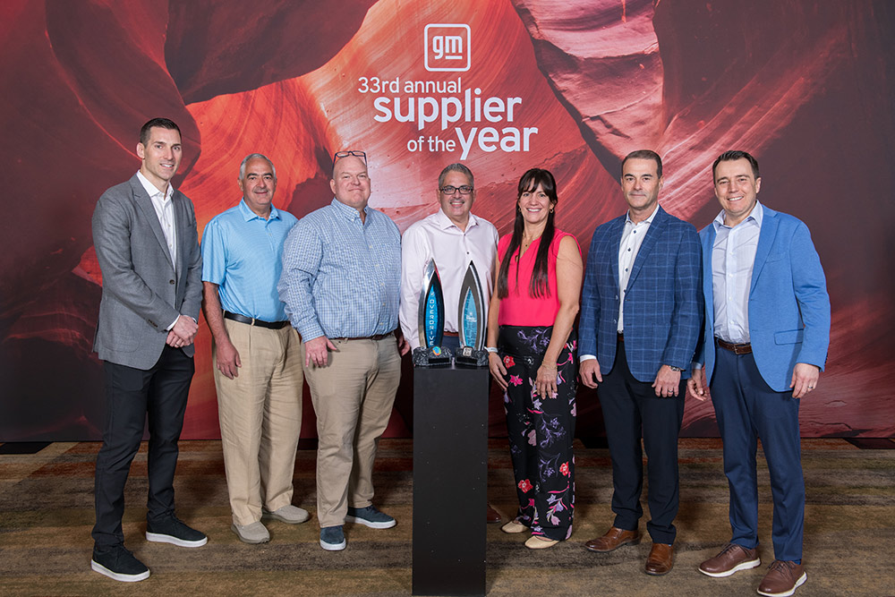 Group of people standing behind GM Supplier of the Year Award